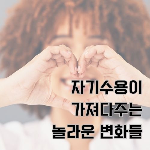 자존감이 튼튼한 빨간 머리를 한 여성이 환하게 웃으며 두 손으로 하트모양을 만들고 있는 사진 