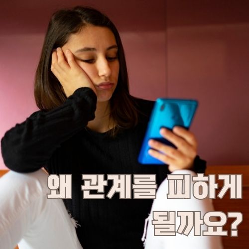 스마트폰을 보며 관계회피증후군으로 고민하는 젊은 여성의 현대적인 고립감 표현
